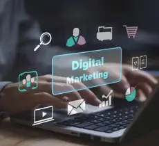 A person typing on a laptop surrounded by digital marketing icons, including graphs, emails, and shopping carts.