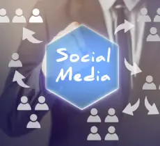 A businessperson's hands are obscured by a glowing blue hexagon with the words "Social Media" surrounded by people icons and circular arrows