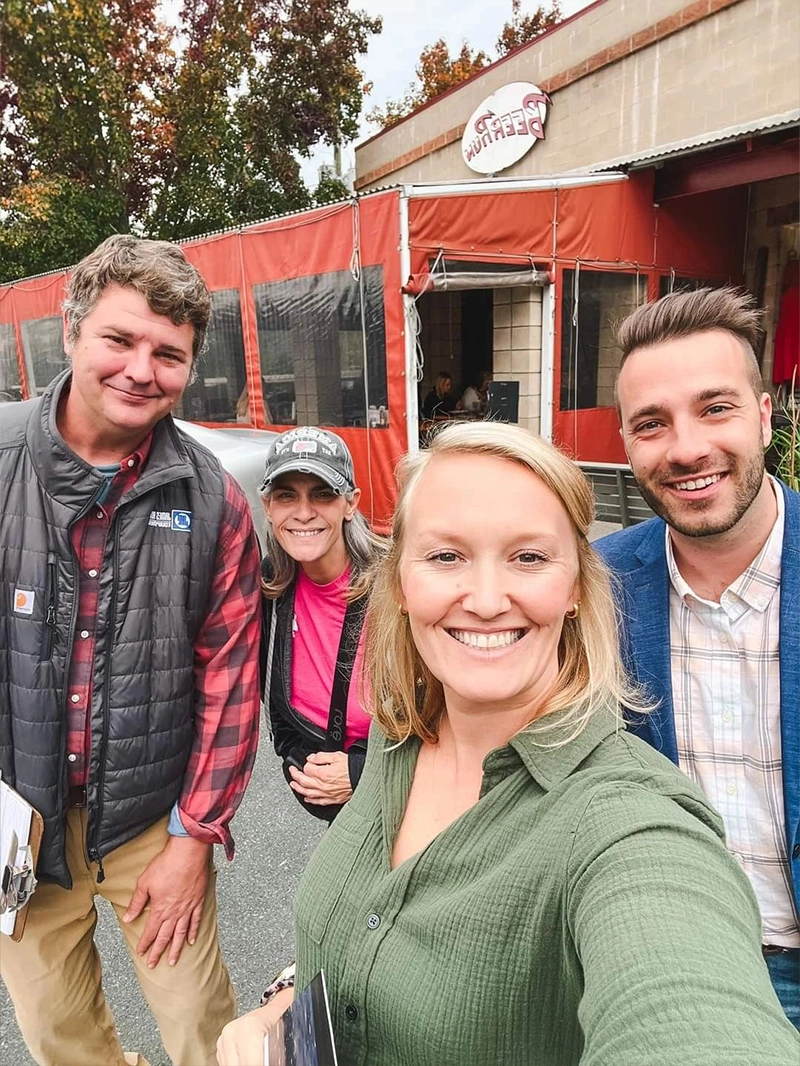 A group of three friends posing for a selfie outside a restaurant, showcasing its vibrant entrance and decor